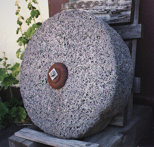 grey grist stone on wooden chair