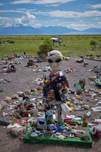 alien statue covered in memorabilia
