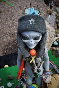 alien statue covered in memorabilia