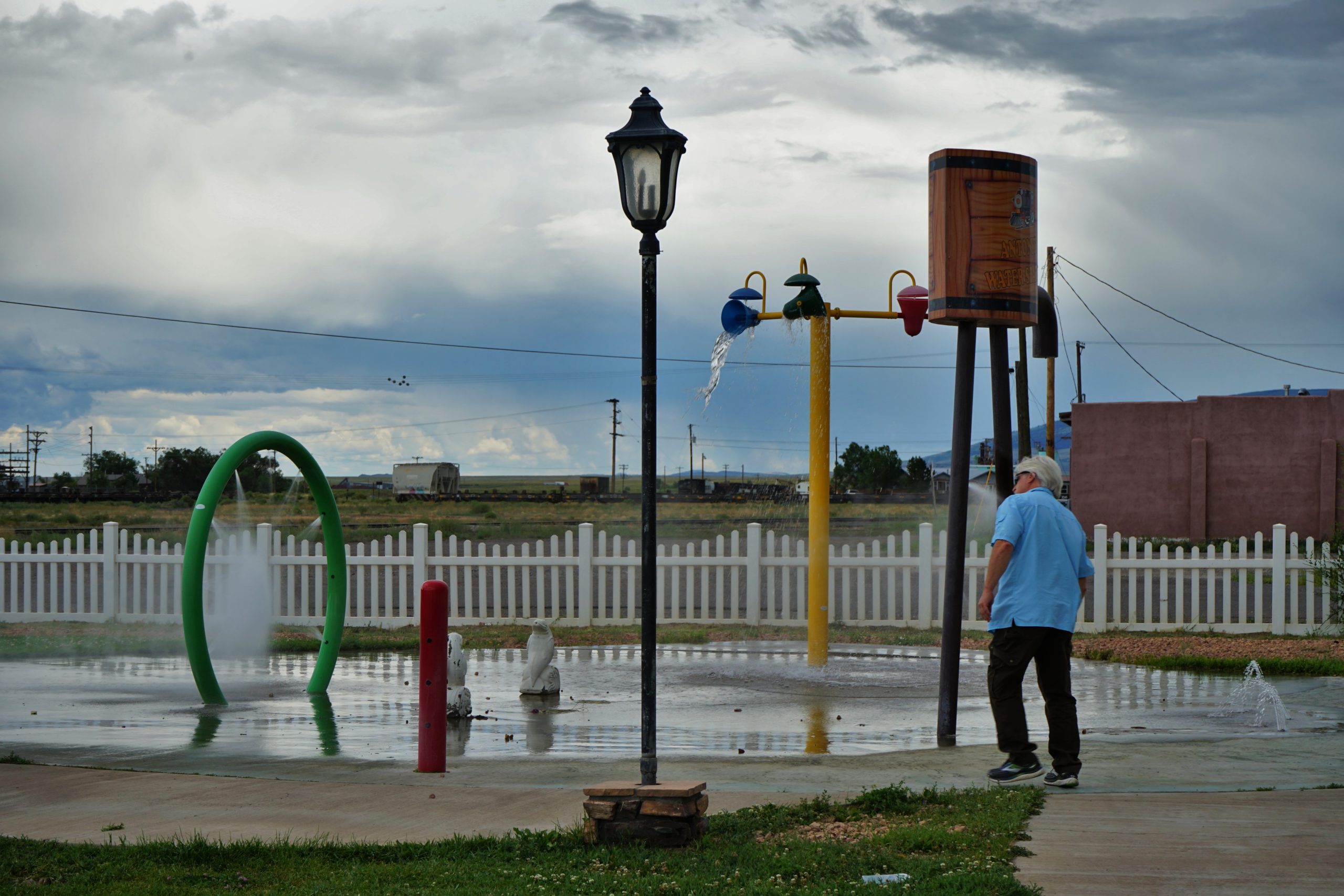 man by water park features at small city park