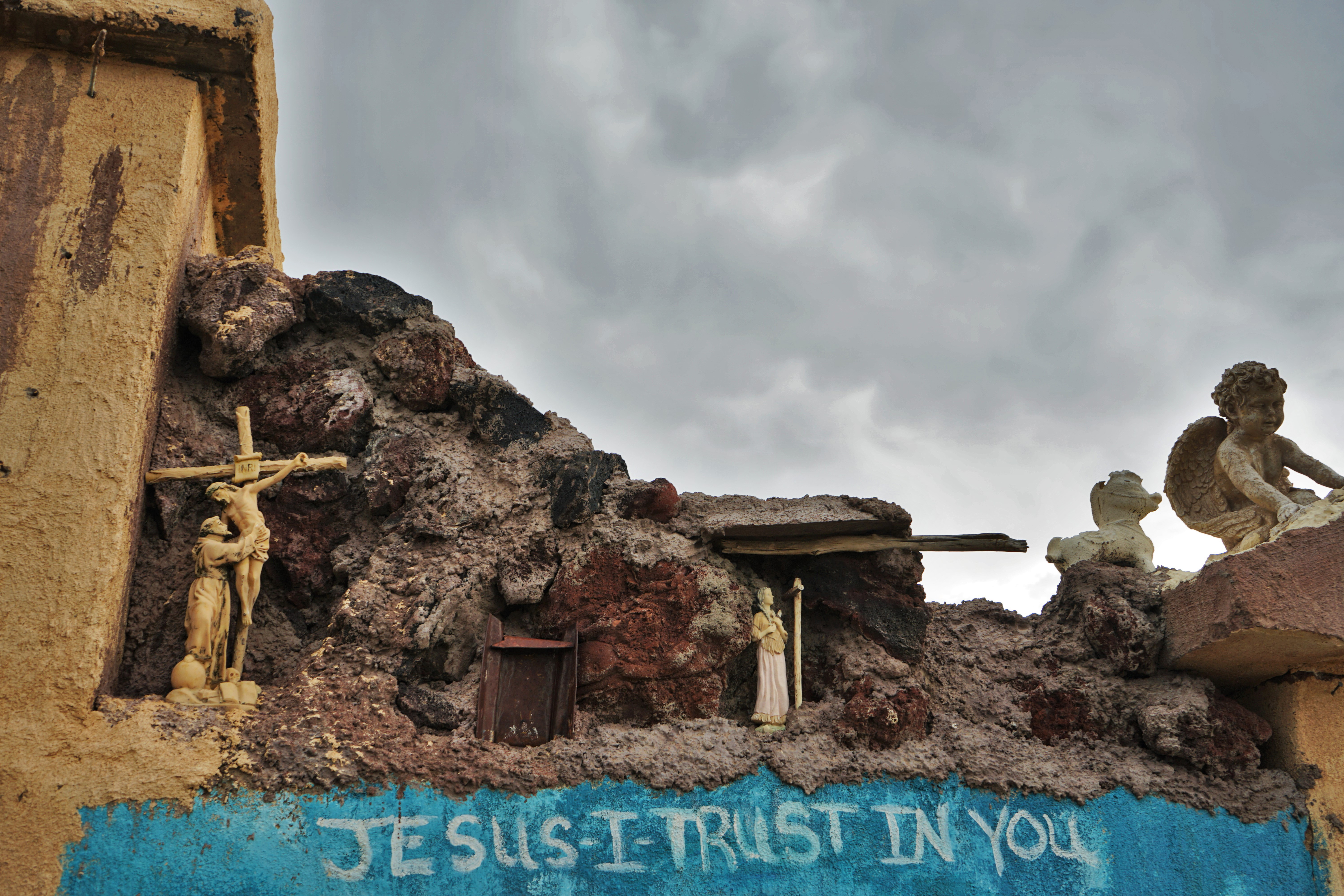 plaster wall of roadside chapel with christian symbols