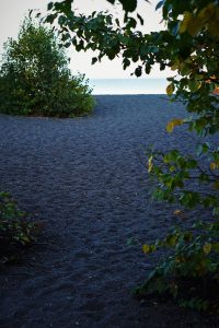 Black sand at a beach on the lake