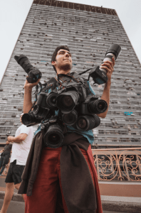 man with lots of cameras around his neck