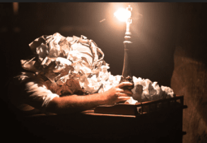 scrunched up papers around head holding light